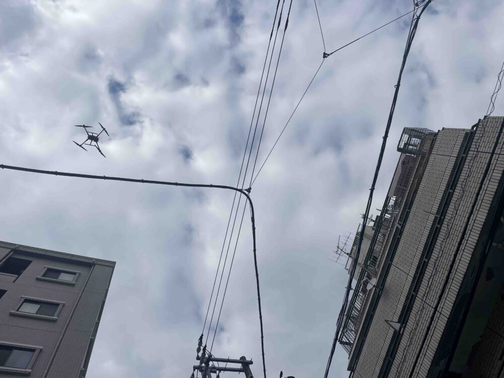 建物の上空を飛行して点検するドローン